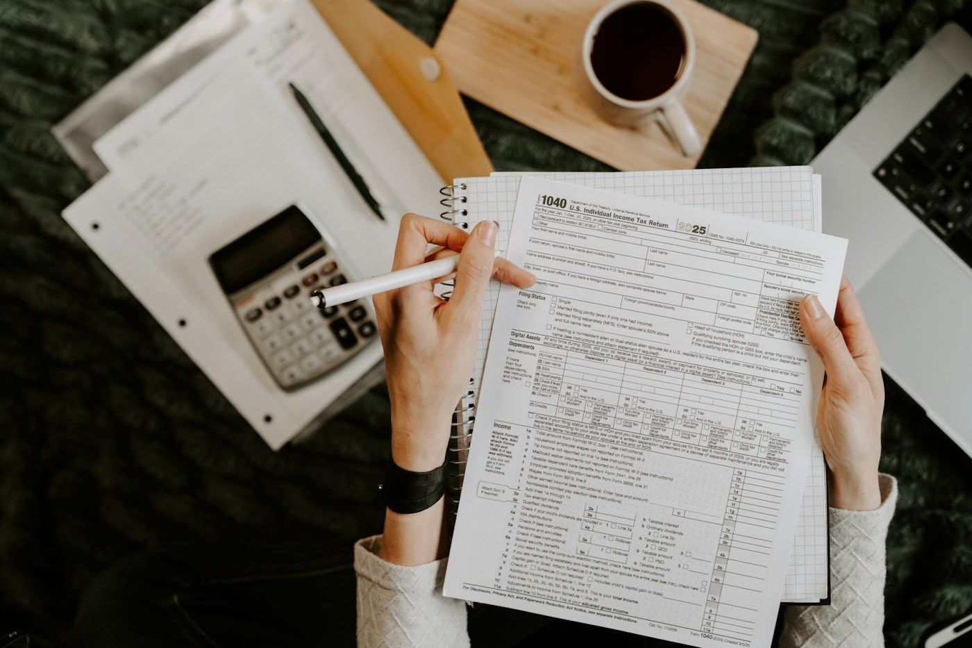 Calculator, laptop and financial documents on a desk